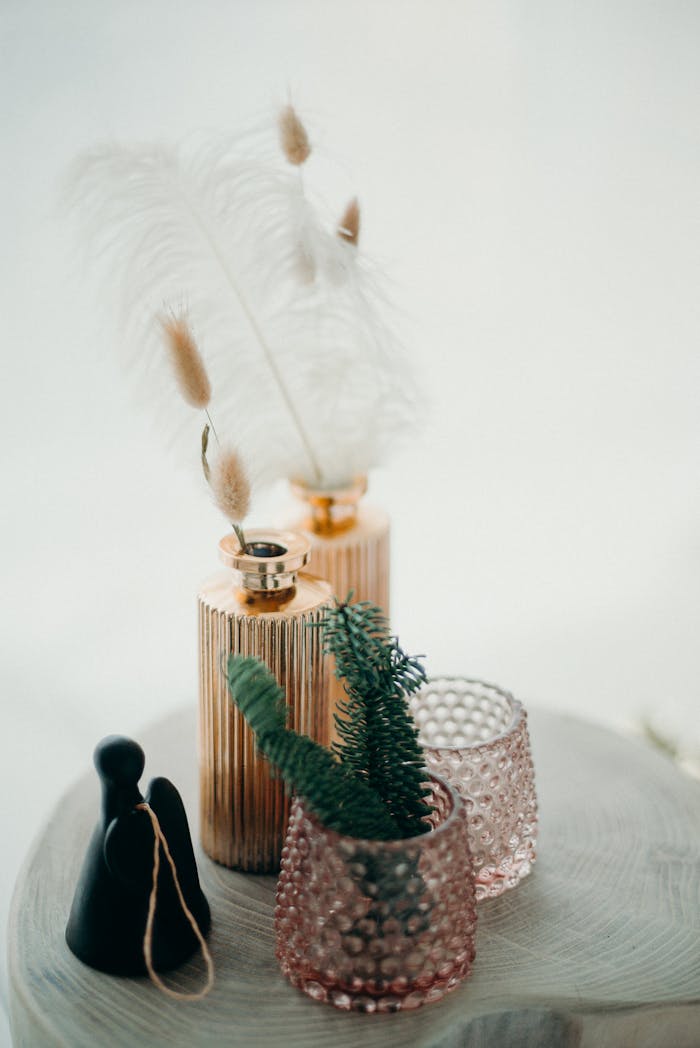 gallery-4 Stylish Christmas decor featuring feathers, glassware, and a small figurine on a coffee table.