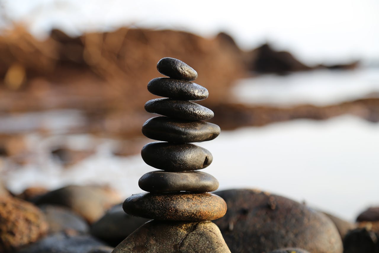 our-services-2 A stack of smooth stones artfully balanced by a waterside, evoking tranquility and zen.